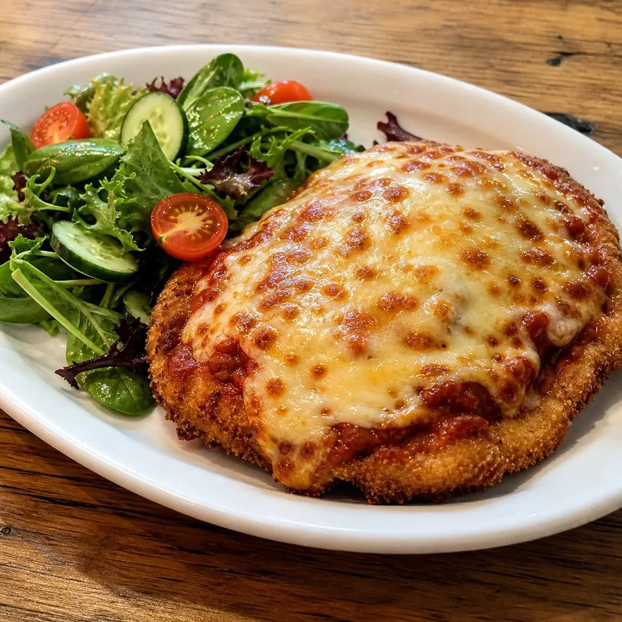Crisp chicken parmigiana with melted cheese and garden salad