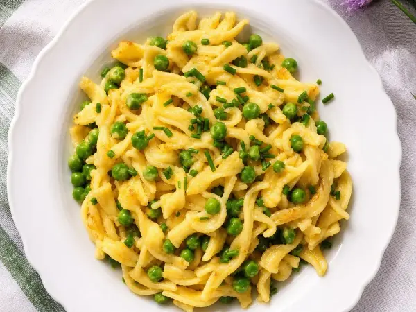Austrian Eiernockerl with Peas and Chives, plated and ready to serve