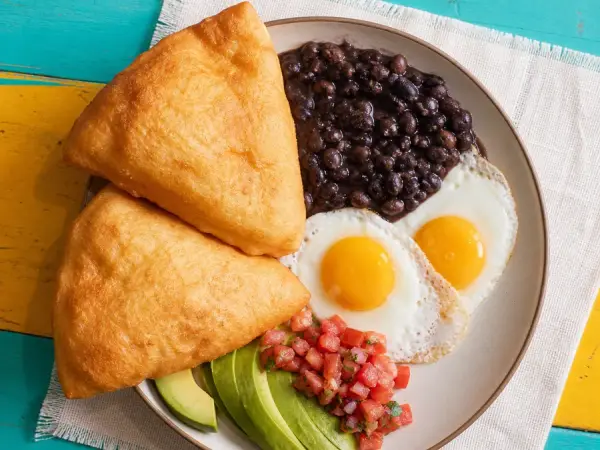 Puffy fry jacks with black beans, eggs, avocado and cheese