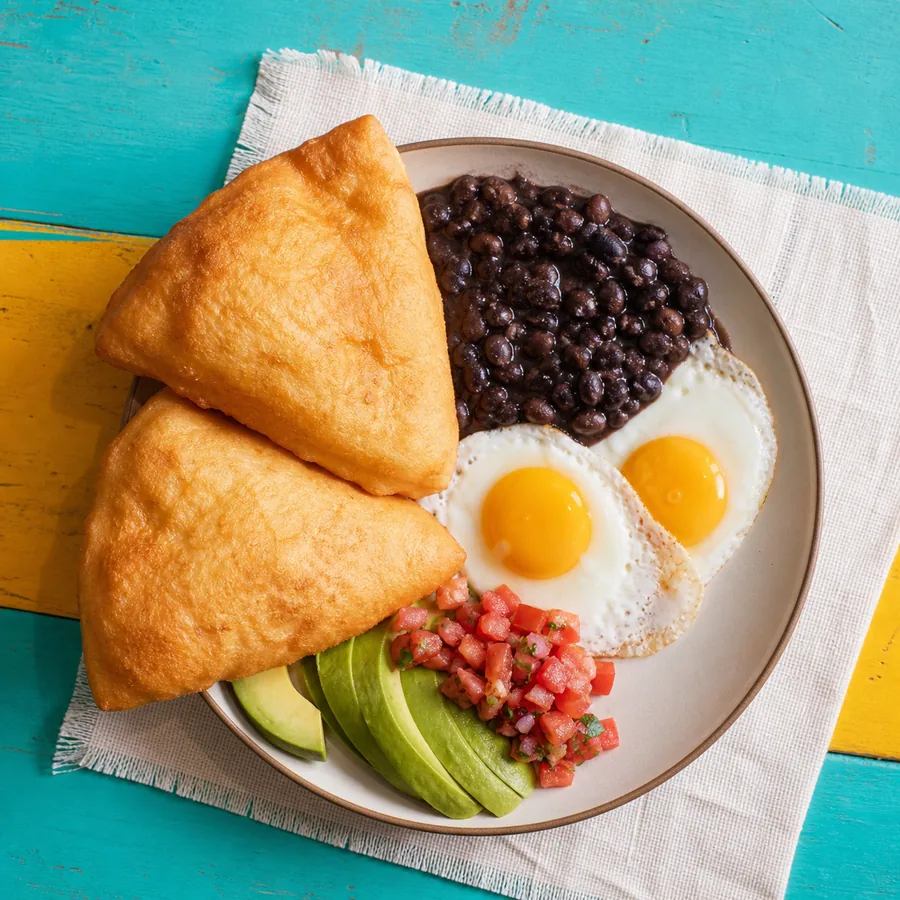 Puffy fry jacks with black beans, eggs, avocado and cheese