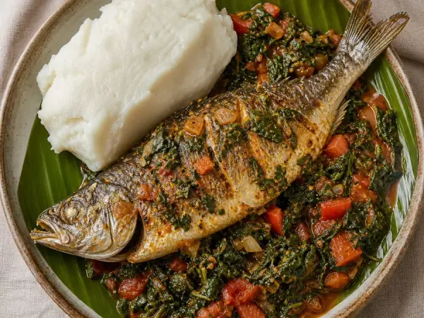 Burundian Mukeke Fish with Tomato Greens, plated as a finished dinner