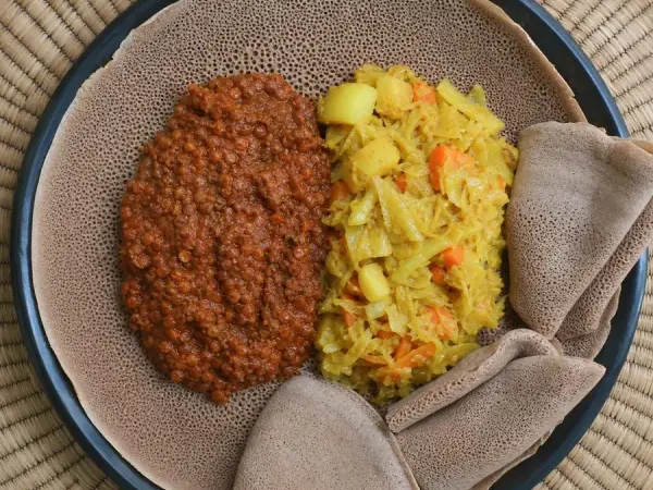 Ethiopian-inspired red lentil misir wot with braised cabbage, carrots, potatoes, and injera