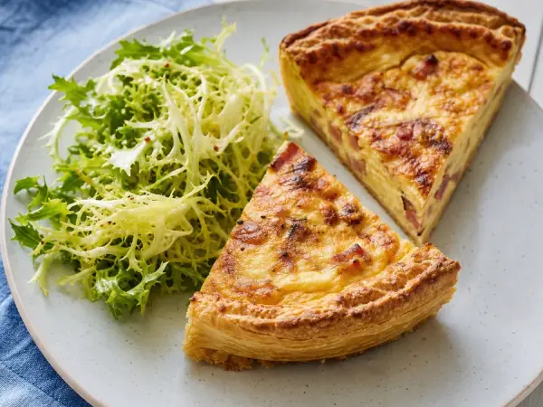 Quiche Lorraine slices with a crisp frisee salad