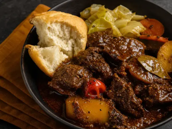 Dark spiced beef stew with cassava bread and fresh herbs
