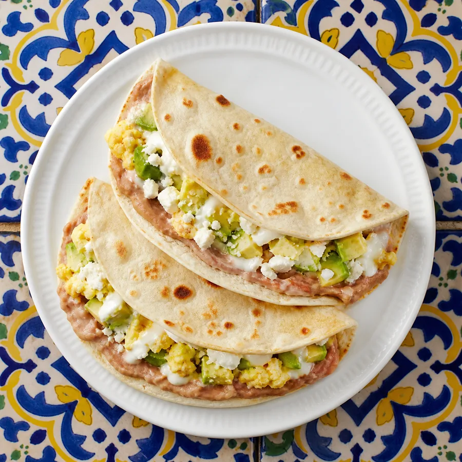 Folded flour tortillas with mashed beans, eggs, avocado and cheese