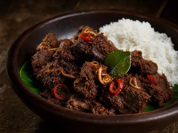 Dark coconut beef rendang skillet with jasmine rice, fried shallots, chile, and lime leaf
