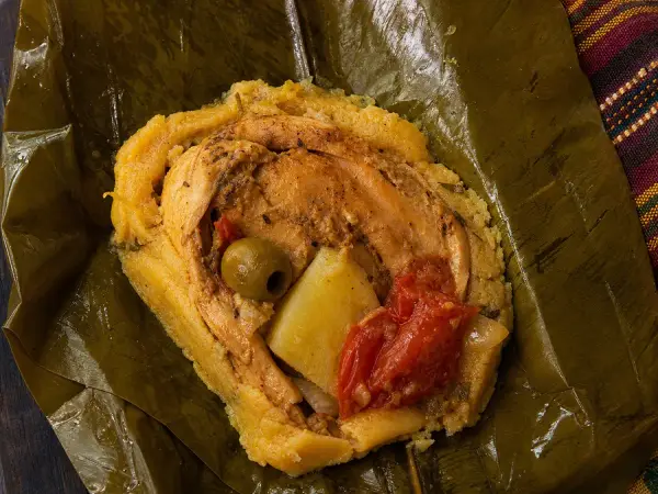 Banana-leaf wrapped chicken masa tamales with vegetables