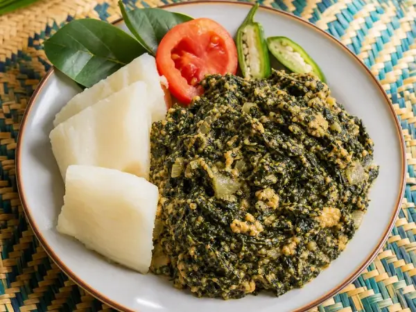 Rwandan Isombe Cassava Leaf and Peanut Stew, plated as a finished dinner