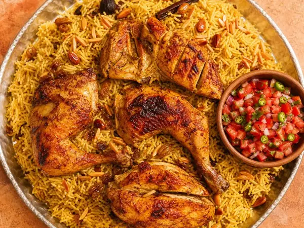 Yemeni Chicken Mandi with tomato salsa on a metal platter